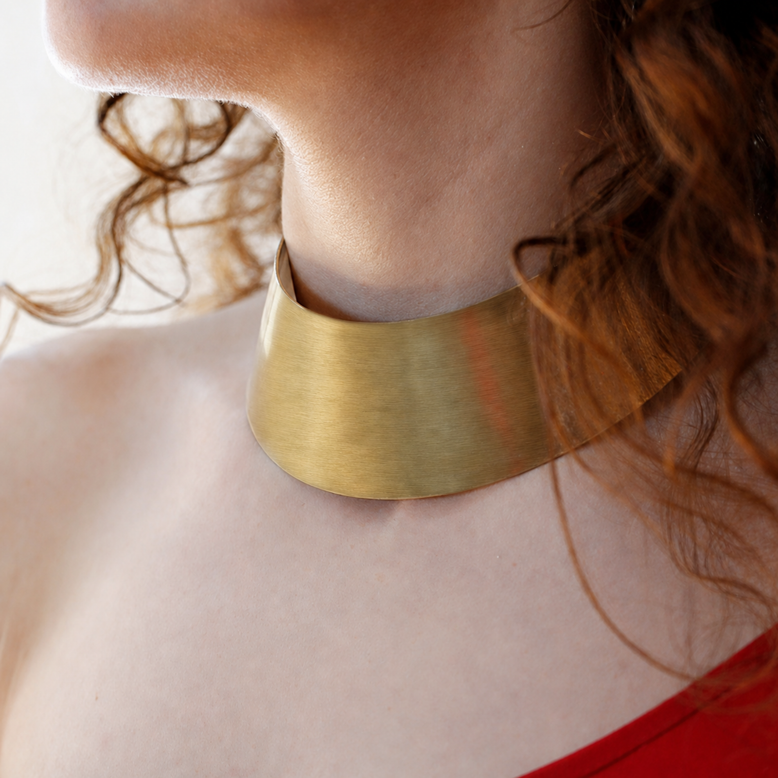Wide handcrafted metal collar worn at the neck